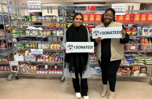 two people holding up "I DONATED" signs at Upper Merion Area Community Cupboard