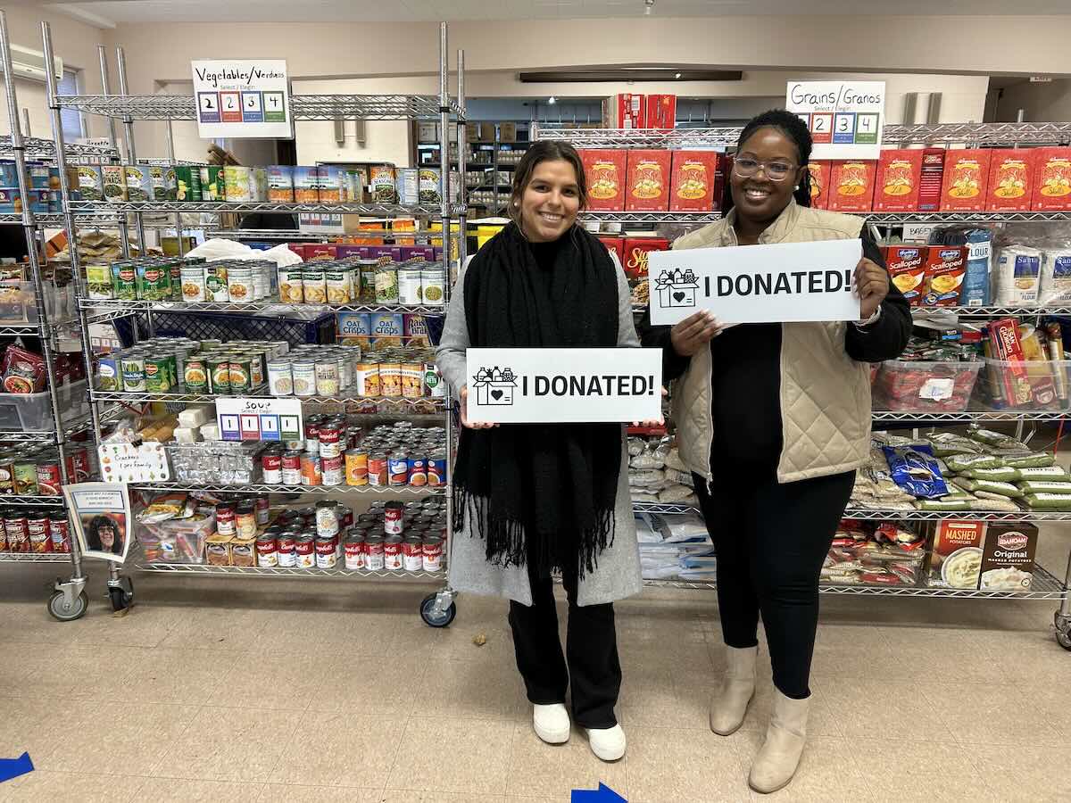 two people holding up "I DONATED" signs at Upper Merion Area Community Cupboard