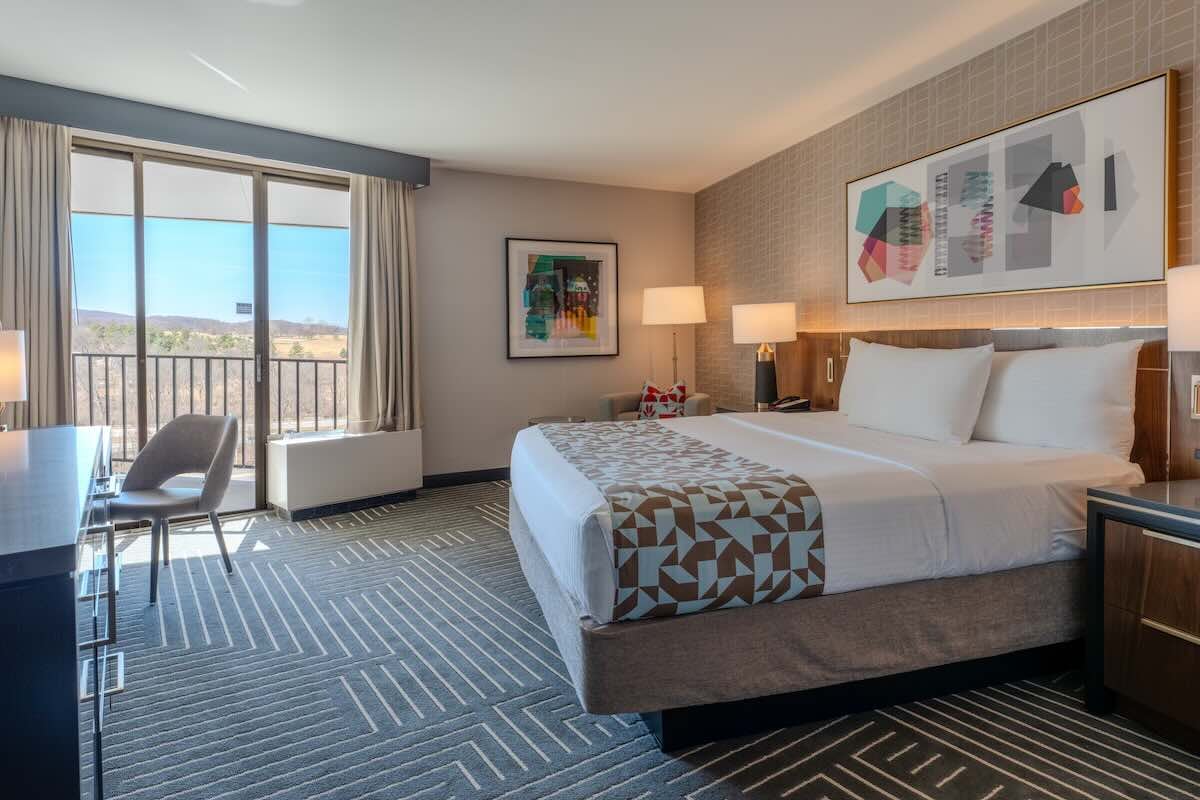 interior of a hotel room with a large bed and window view
