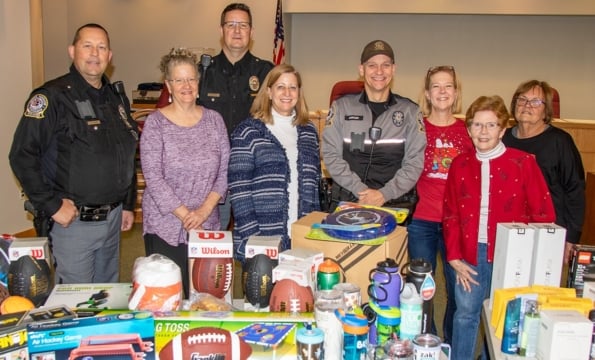 group of people standing behind a table of donations