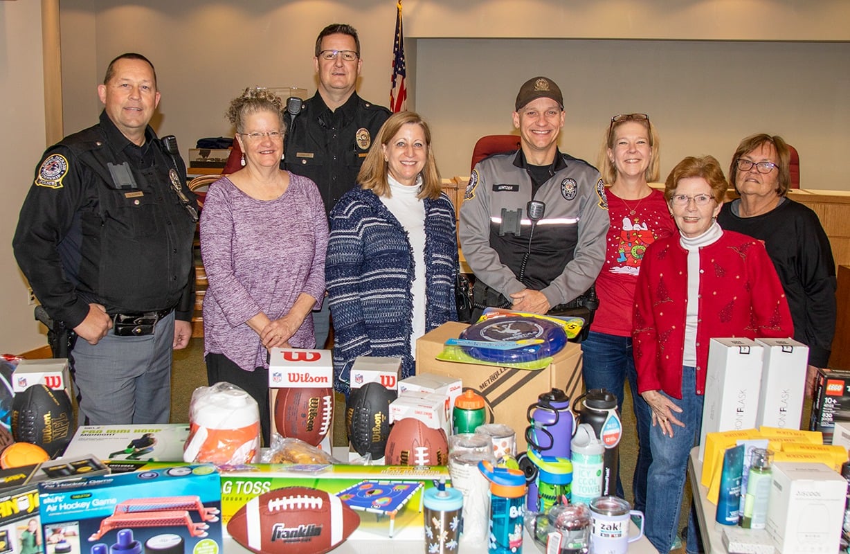group of people standing behind a table of donations