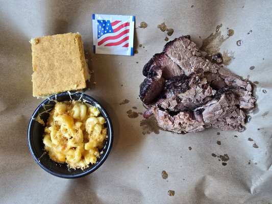 mac and cheese and meat on a paper with cornbread and an american flag wipe package