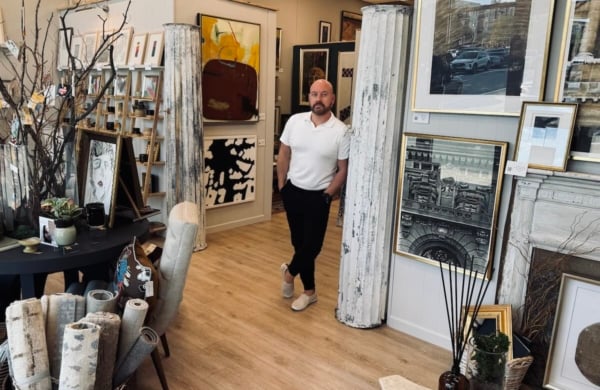 person standing in art gallery surrounded by paintings