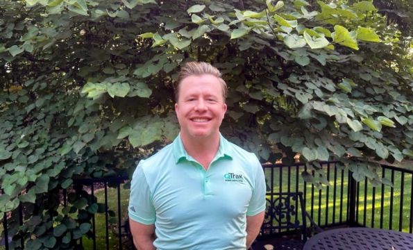 photo of man outdoors in front of large shrubbery