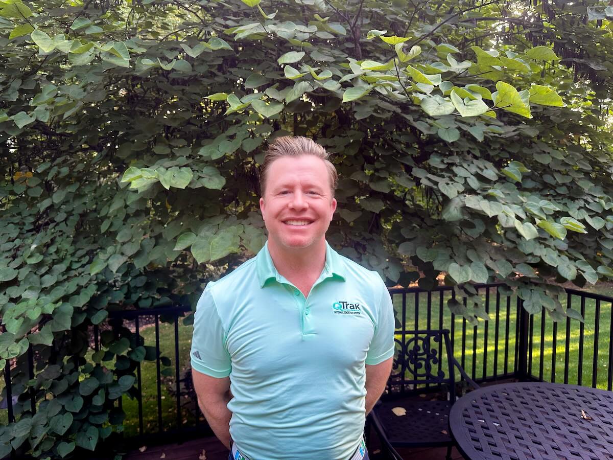 photo of man outdoors in front of large shrubbery
