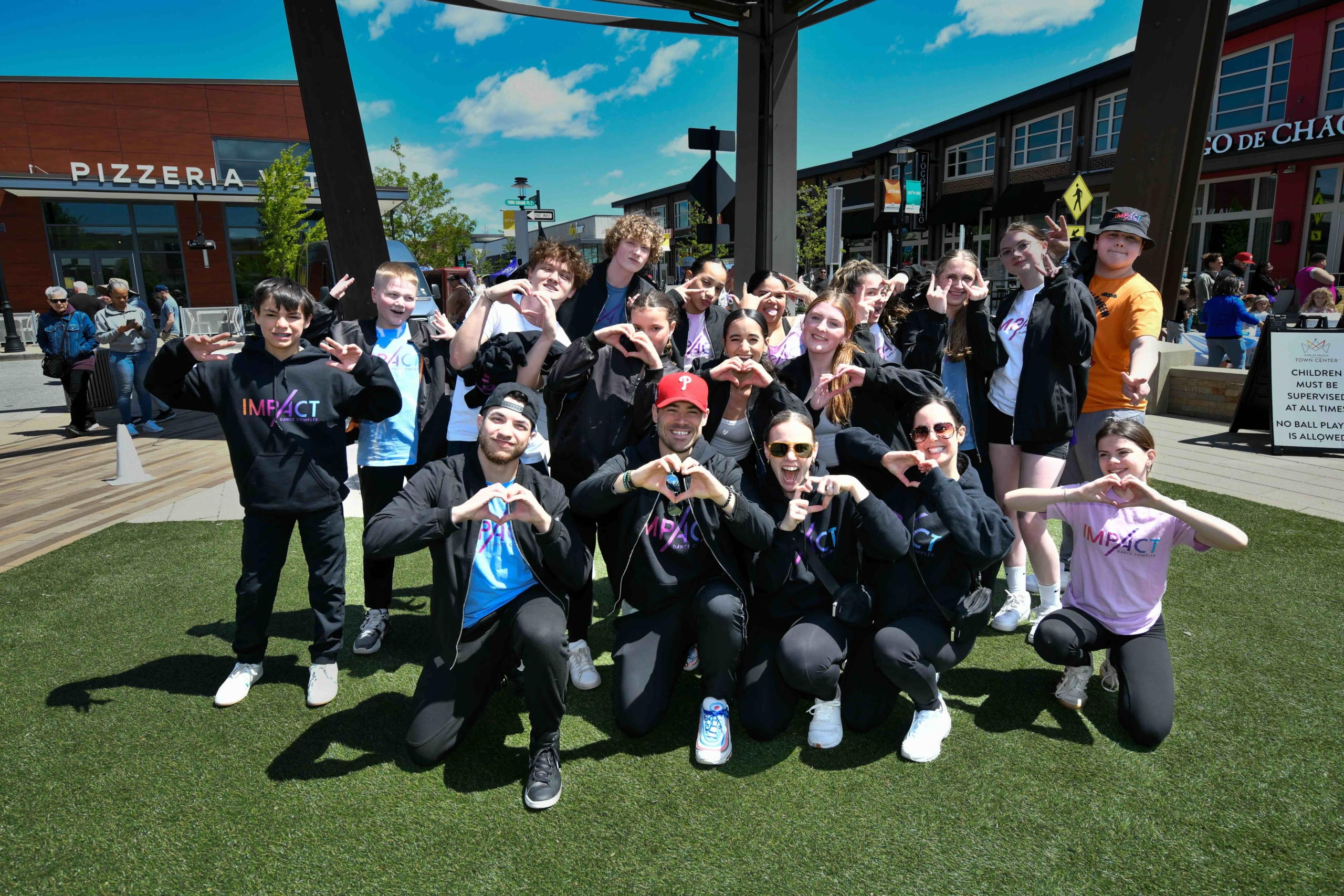 Group of people making hearts with their hands outdoors