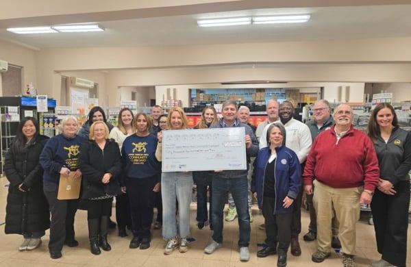 group of people holding a large check