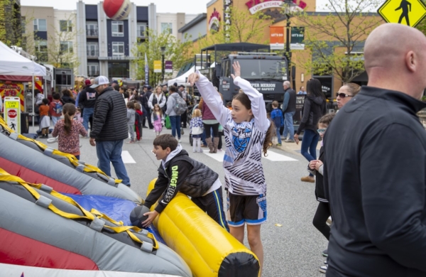child playing basketball with block party crowd in background