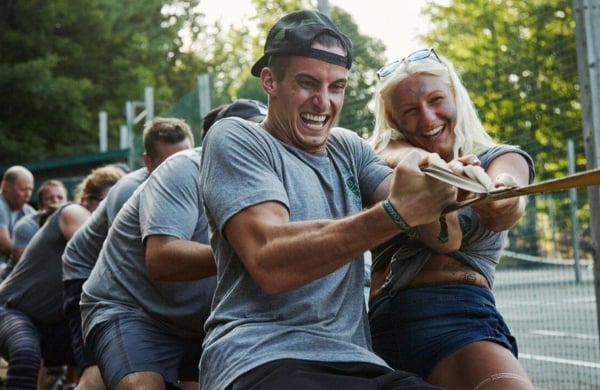 group of adults pulling on a rope outdoors