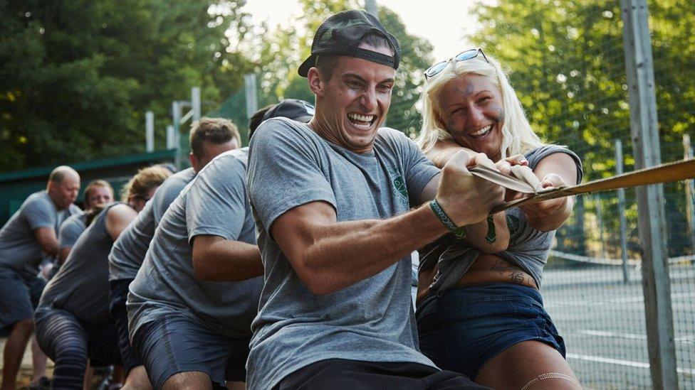 group of adults pulling on a rope outdoors