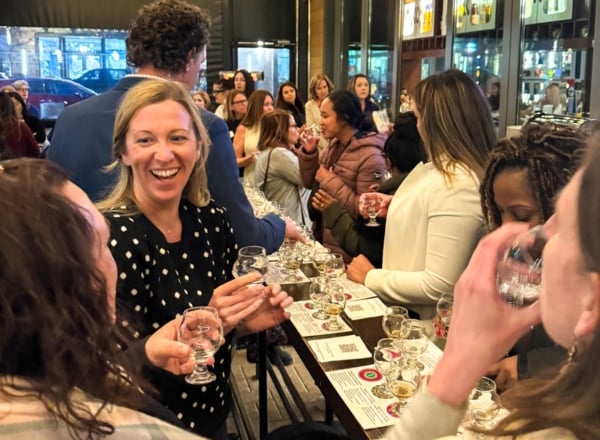 people talking at a bar holding glasses