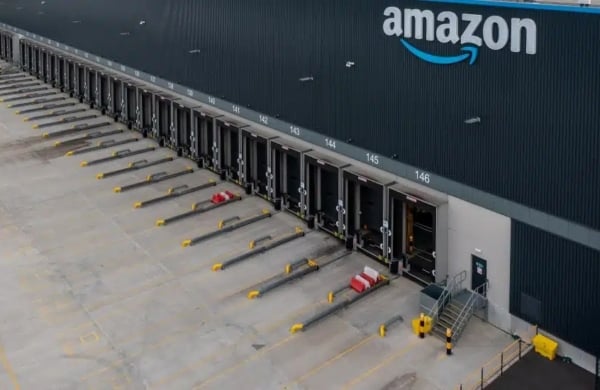 exterior of a large, blue amazon warehouse with truck ports