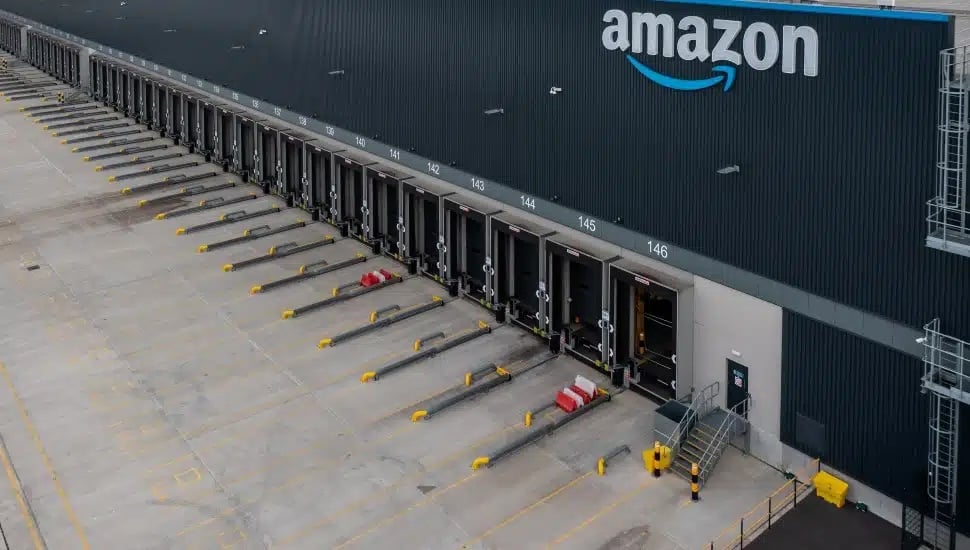 exterior of a large, blue amazon warehouse with truck ports