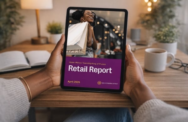 hands holding a tablet with a retail report cover on it
