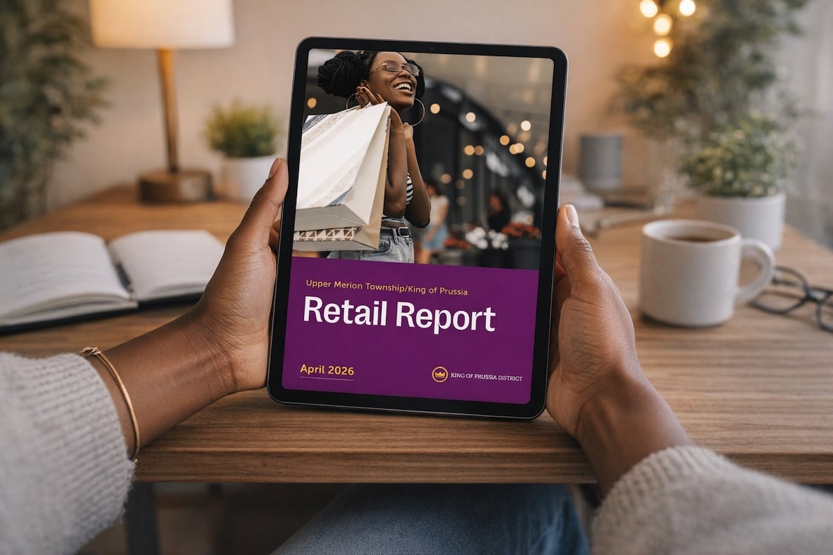 hands holding a tablet with a retail report cover on it