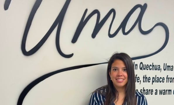 woman standing below a sign that says "Uma"