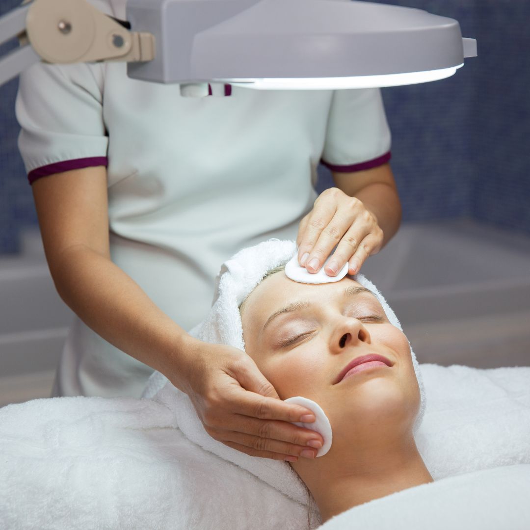a person laying under a bright light getting a facial