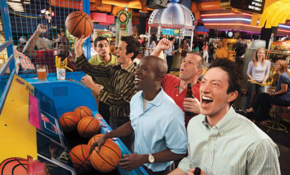 people smiling while playinga basketball arcade game
