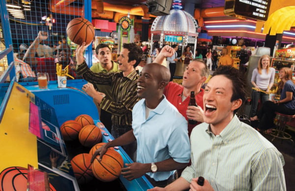 people smiling while playinga basketball arcade game