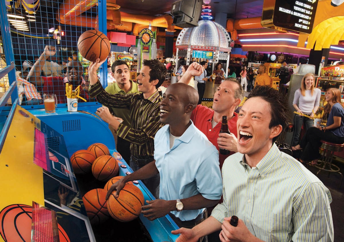 people smiling while playinga basketball arcade game