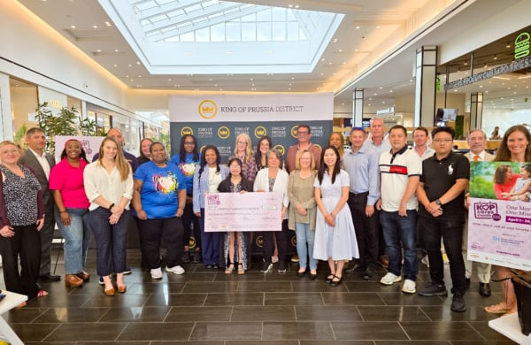group of people holding a.large check