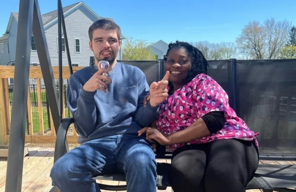 two people sitting on an outdoor swing and smiling