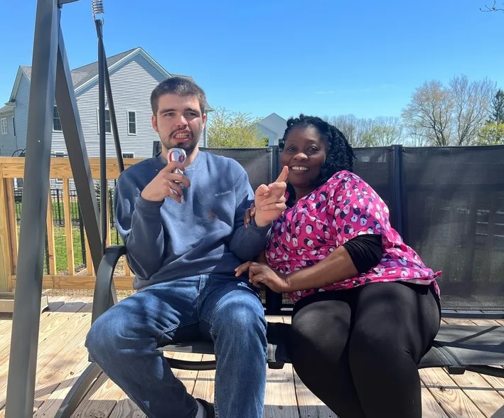 two people sitting on an outdoor swing and smiling