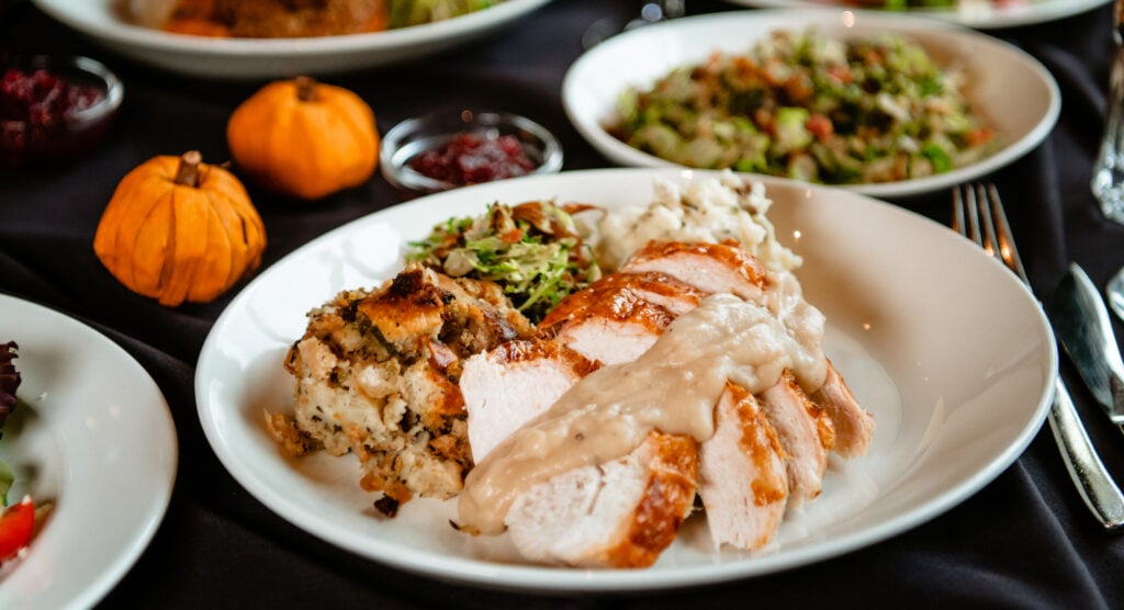 thanksgiving plate of turkey, vegetables and stuffing on a table